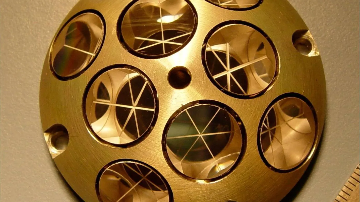 eine goldene Metallkugel/ein goldener Metallkreis mit anderen Kreisen darin, in denen jeweils drei halbierende Linien zu sehen sind. alle in Goldtönen.