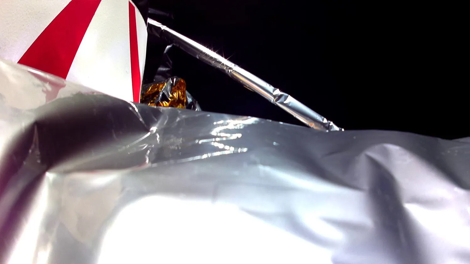 Nahaufnahme einer Schutzplane, die ein Raumfahrzeug umgibt, wobei auch eine Strebe und ein schwarzer Zwischenraum sichtbar sind