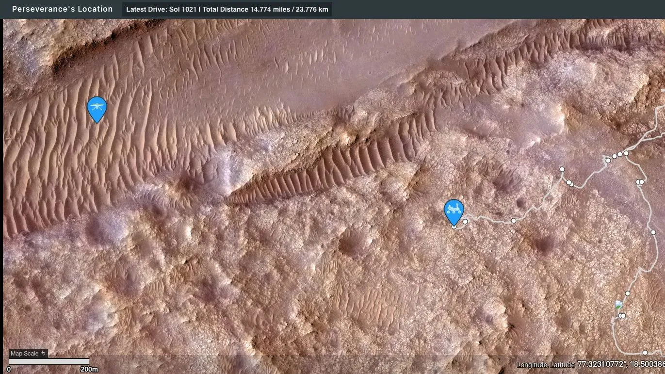 Luftaufnahme des rötlichen Marsbodens, mit blauen Symbolen, die die Standorte des NASA-Rovers Perseverance und des Ingenuity-Hubschraubers anzeigen