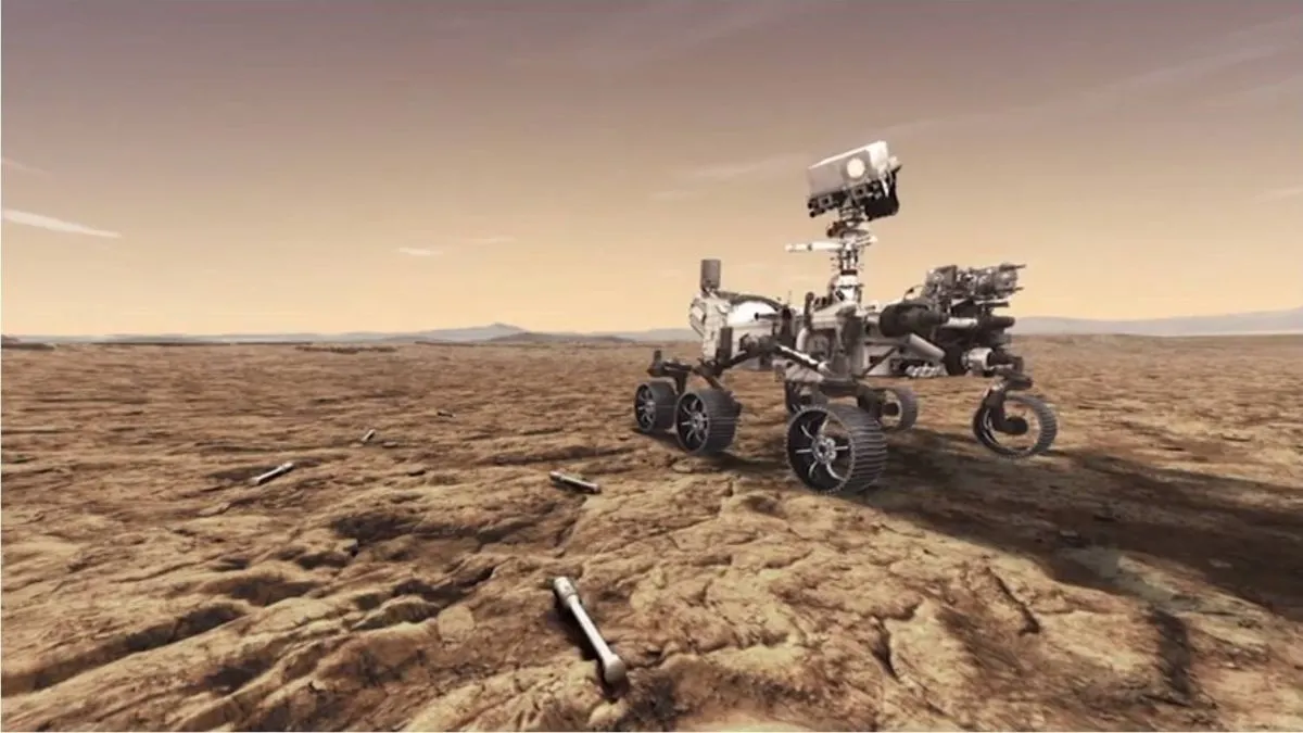 ein Rover mit Rädern und einer Kamera an einem halsähnlichen Anhängsel fährt über einen kargen, rot-orangen Planeten