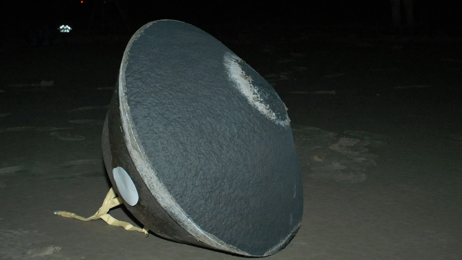 Ein mittelgroßer grauer Behälter in Form eines Kreisels auf dem Boden.