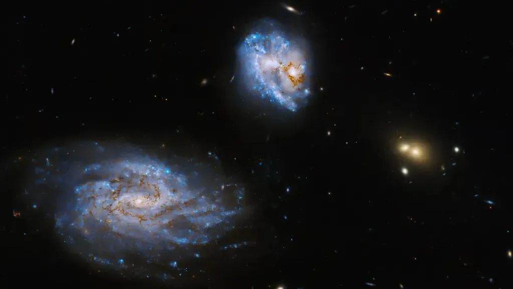 drei Galaxien hängen im Raum mit kleineren darüber