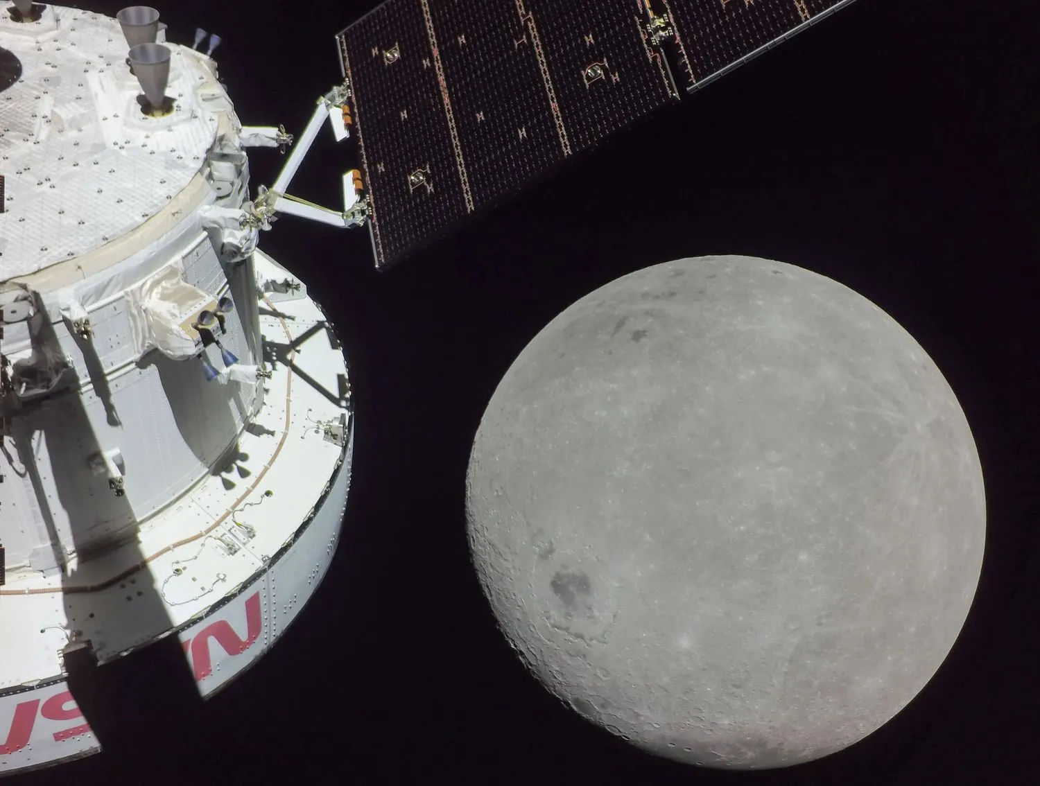 Das hintere Ende eines Raumschiffs sitzt im Bild mit dem Mond, der sich nähert.