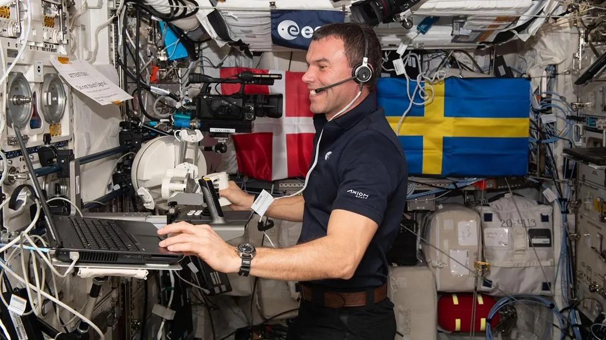 ein Astronaut an einem Laptop in der Raumstation vor dem Hintergrund von Flaggen