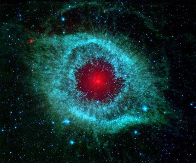 Ein weißer Zwerg leuchtet rot im Zentrum einer schimmernden Gas- und Staubwolke im Helix-Nebel, der sich 700 Lichtjahre entfernt im Sternbild Wassermann befindet.