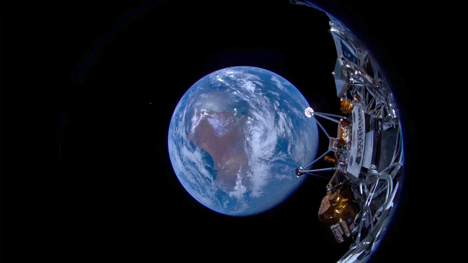 Foto, das einen Teil eines silber- und goldfarbenen Raumschiffs mit der Erdkugel und der Schwärze des Weltraums im Hintergrund zeigt.
