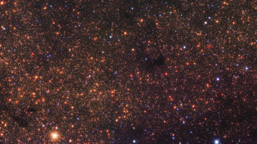 Deep-Space-Foto mit Tausenden von rötlich-orangen Punkten, von denen jeder ein entfernter Stern ist