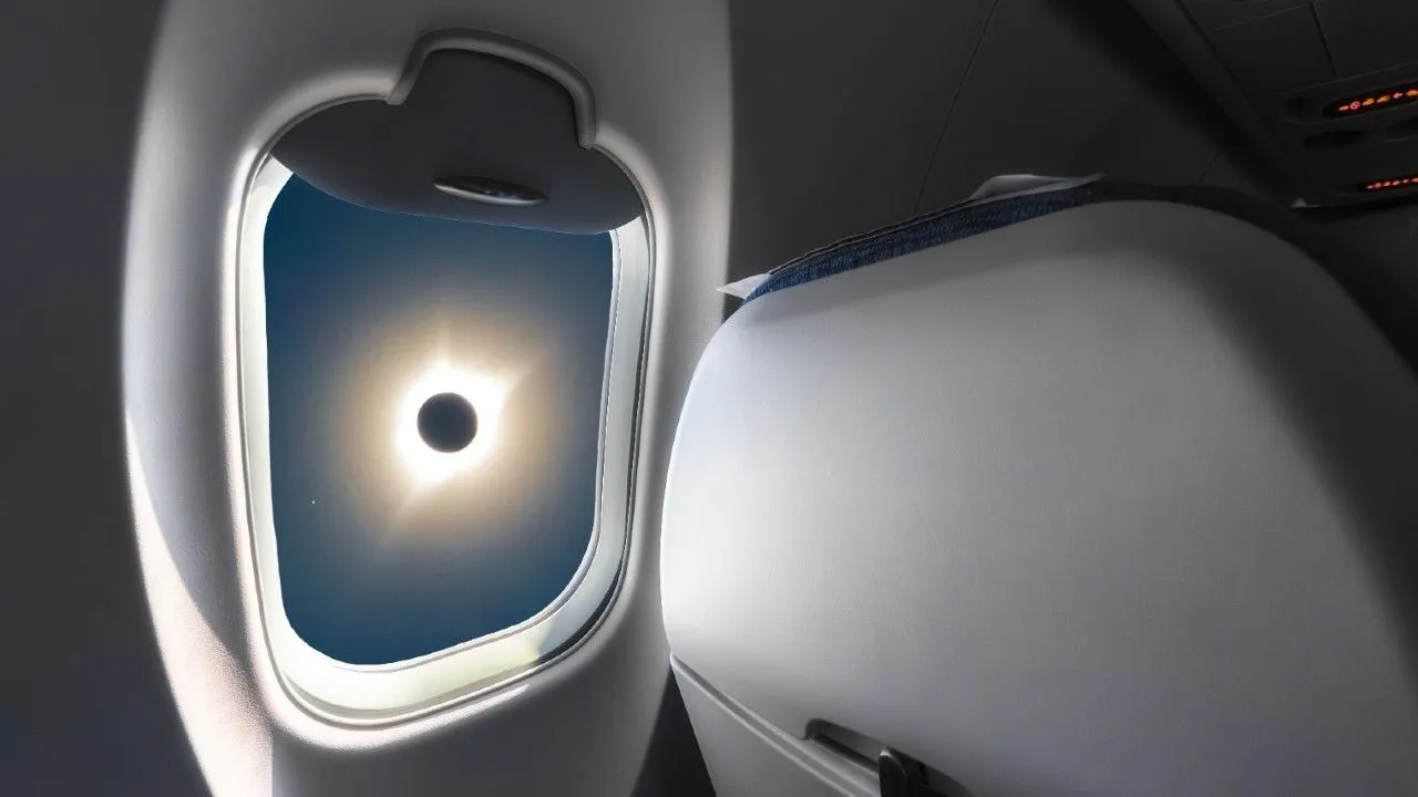 eine totale Sonnenfinsternis durch ein Flugzeugfenster gesehen