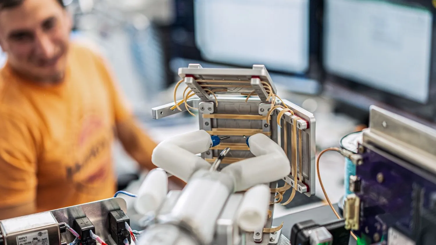ein roboterhandähnliches Gerät, das in einem Labor nach Gummibändern greift