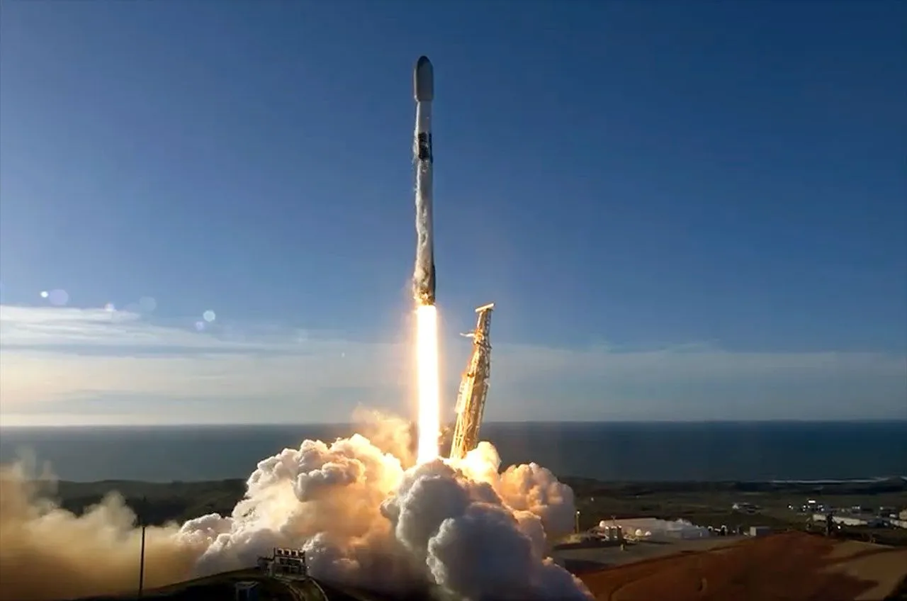 eine schwarz-weiße Spacex Falcon 9 Rakete startet in einen blauen Himmel.