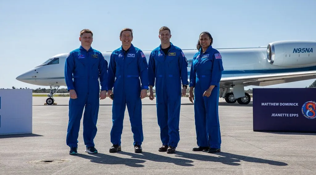Vier Crew-8-Astronauten in ihren blauen NASA-Fluganzügen lächeln für ein Gruppenfoto nach der Ankunft an ihrem Startplatz.