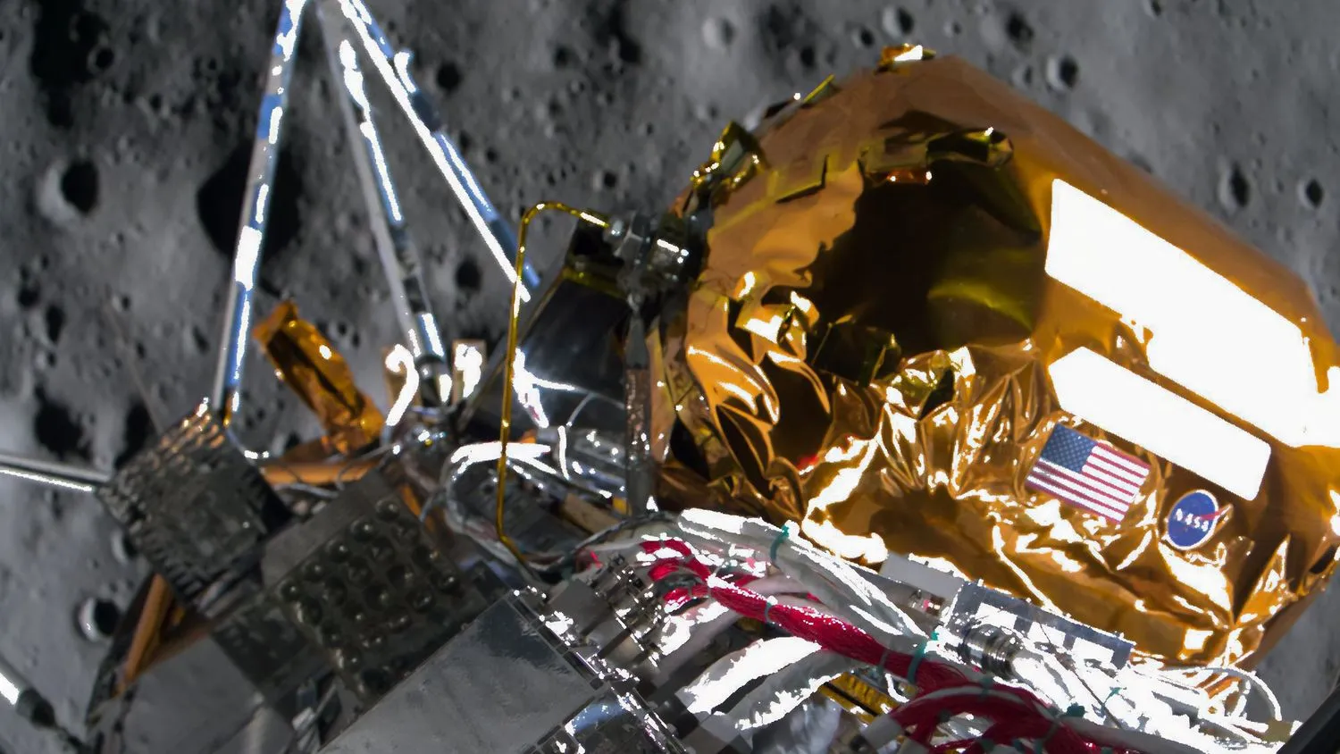 Nahaufnahme eines Teils eines gold- und silberfarbenen Raumfahrzeugs, mit der grauen Mondoberfläche im Hintergrund