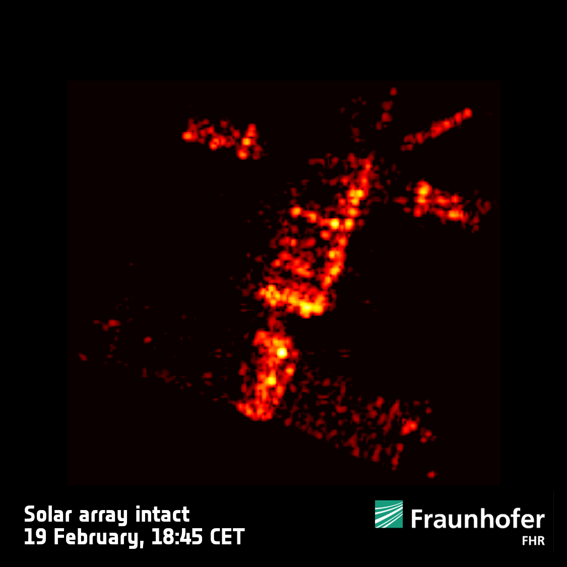 ein körniges rotes Bild eines H-förmigen Satelliten, der sich vor einem schwarzen Hintergrund dreht