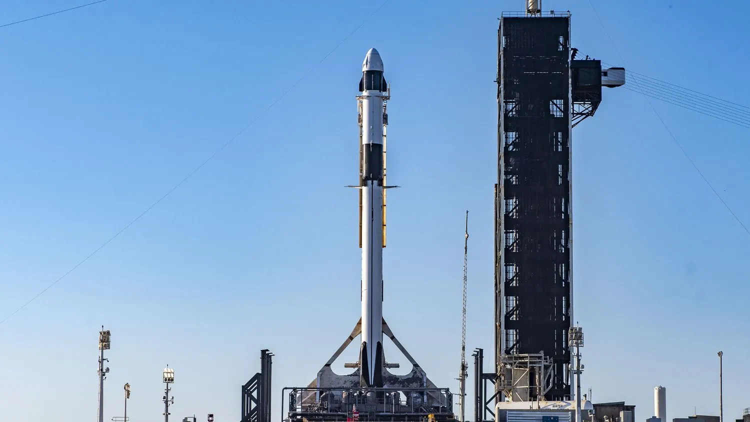 Eine weiß-schwarze SpaceX Falcon 9 Rakete steht auf ihrer Startrampe vor dem Start.