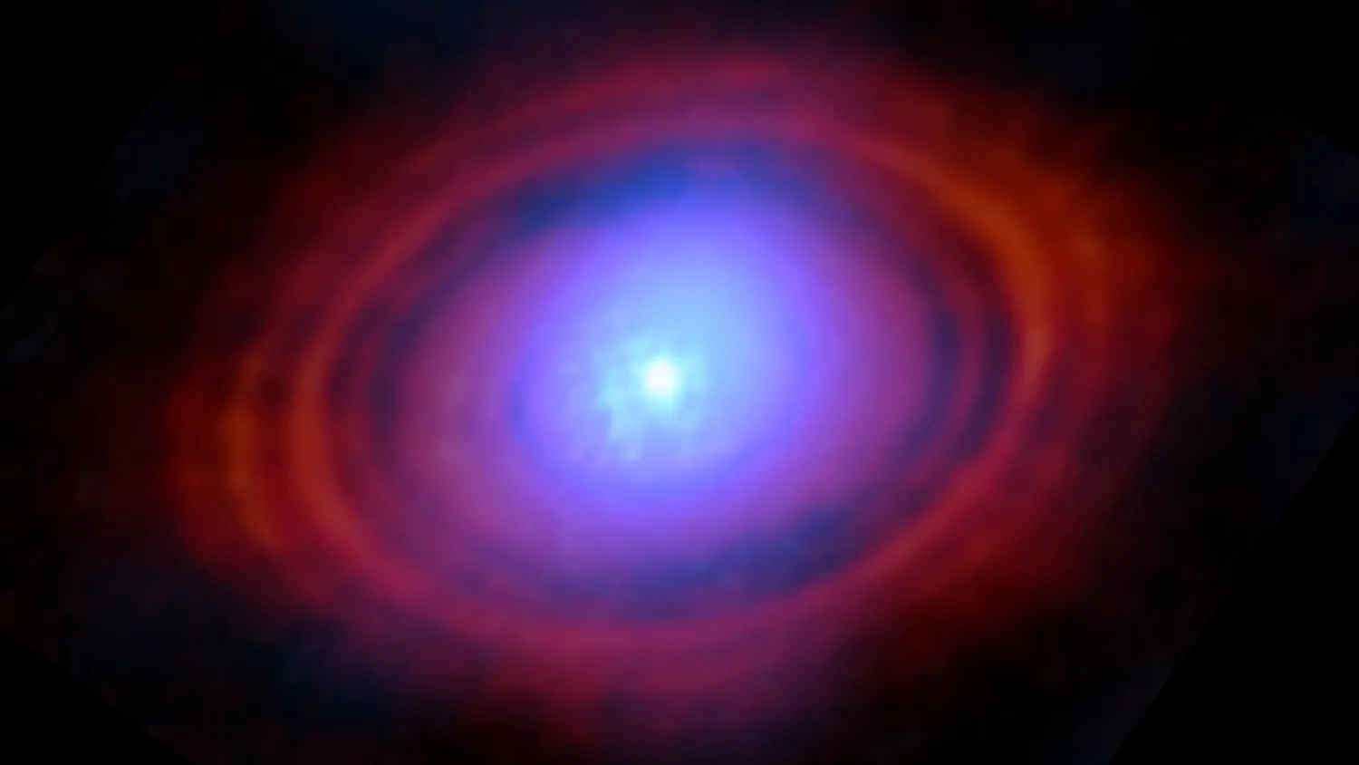Eine leicht verschwommene blaue Kugel in der Mitte des Bildes ist von einer Scheibe mit lila und dann roten Schleiern umgeben. Die Struktur ist vor einem schwarzen Hintergrund zu sehen.