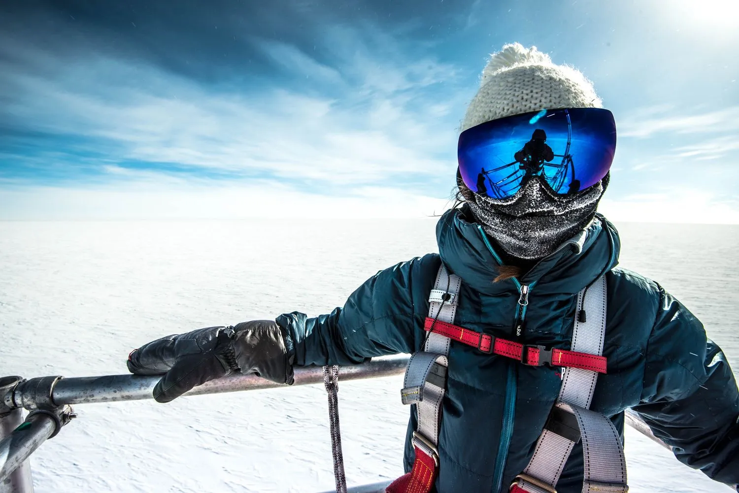 eine Person in Schutzkleidung posiert für ein Porträt inmitten einer kargen Schneelandschaft