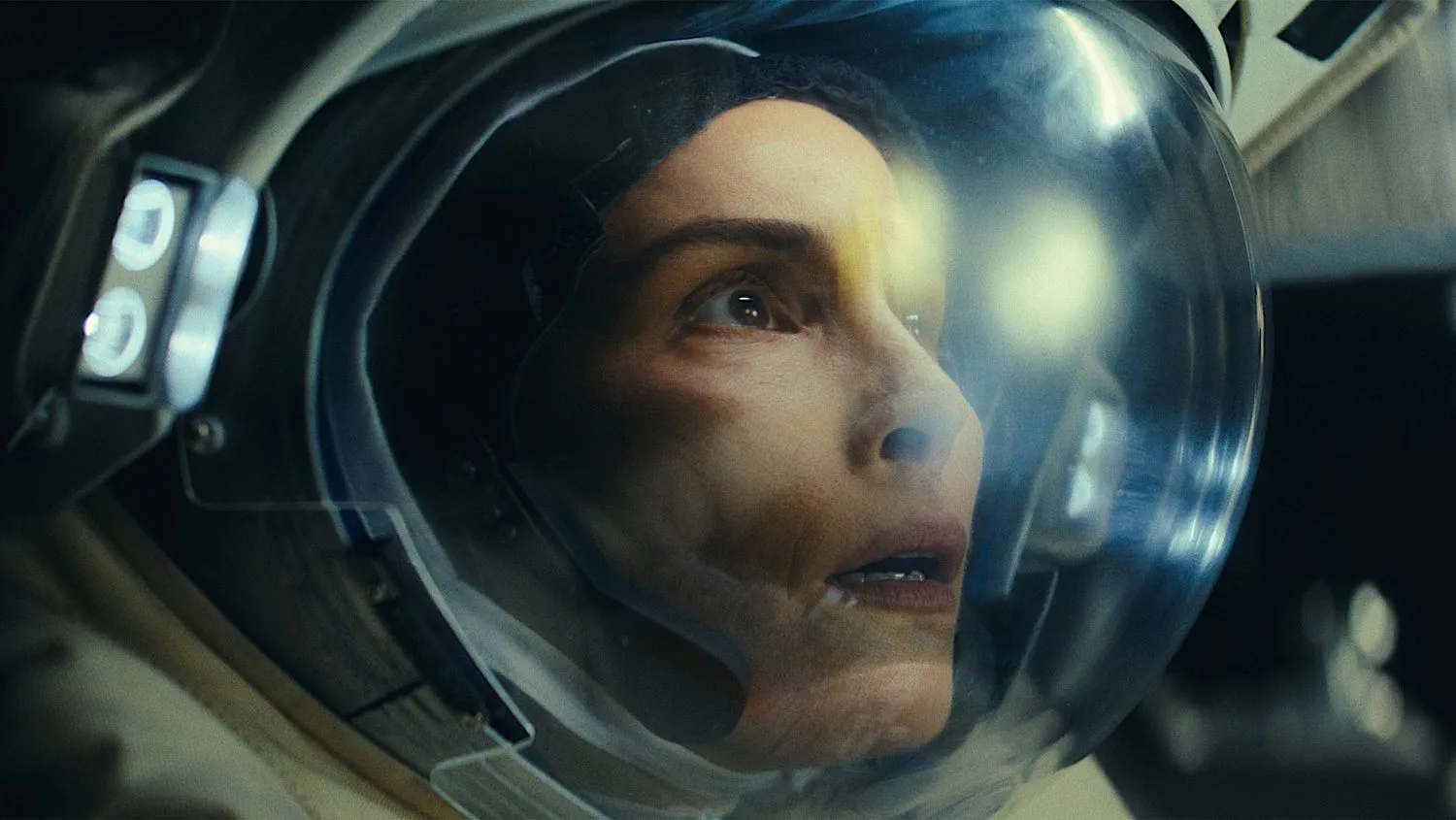 eine Frau in einem Astronautenhelm sieht verängstigt aus
