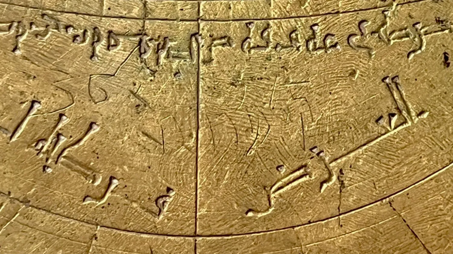 Nahaufnahme eines astronomischen Instruments aus Bronze mit arabischen und hebräischen Markierungen und westlichen Ziffern.