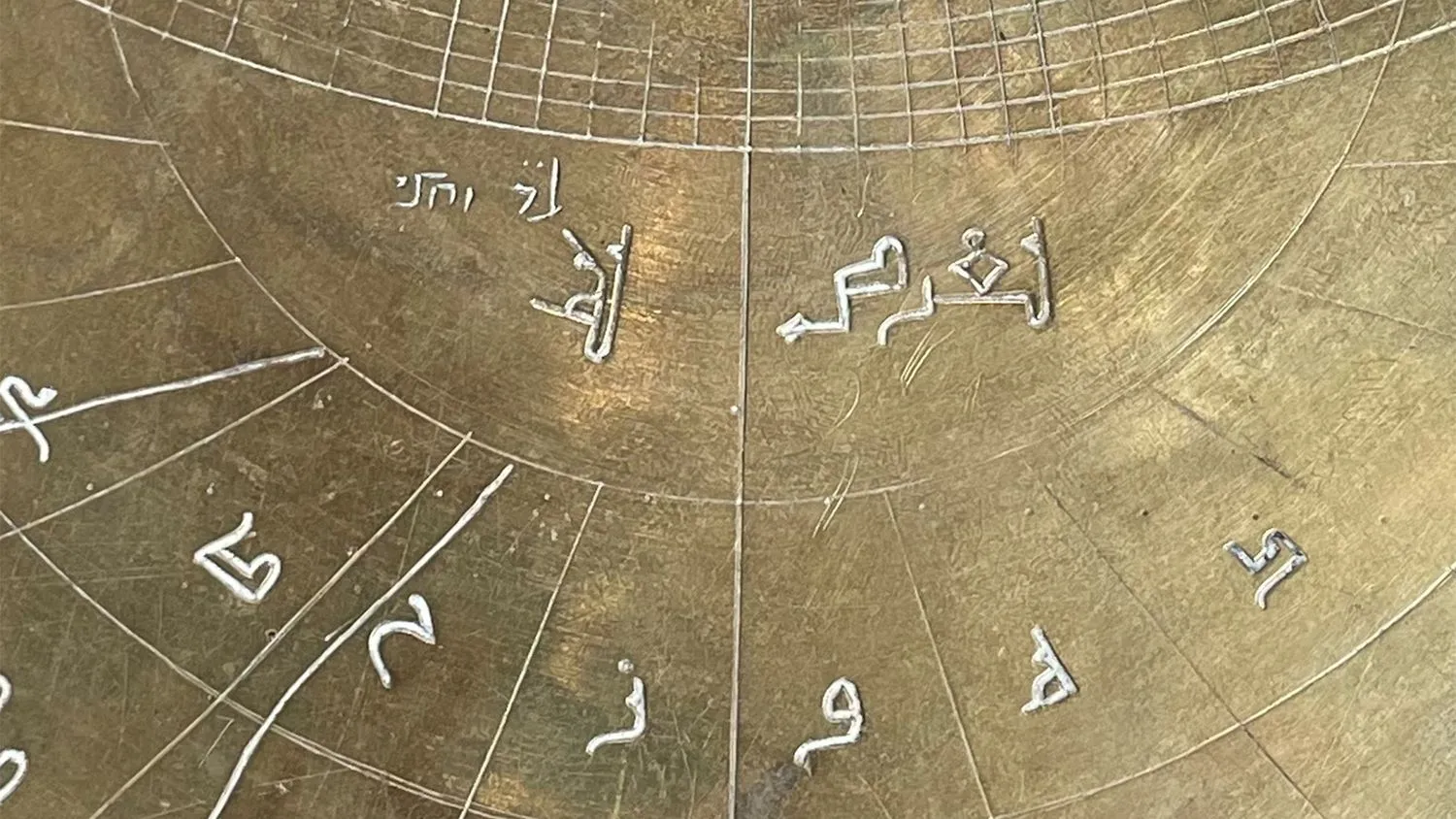 Nahaufnahme eines astronomischen Instruments aus Bronze mit arabischen und hebräischen Markierungen.