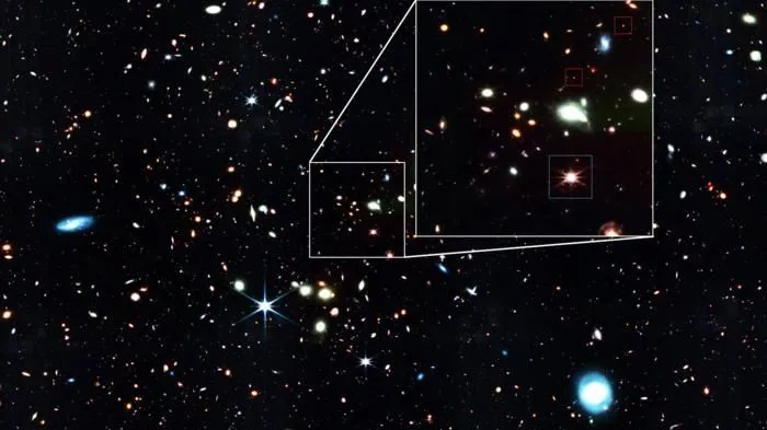 Ein Bild von einem sternenübersäten Ausschnitt des Weltraums; einige kleine rote Funken sind hervorgehoben.