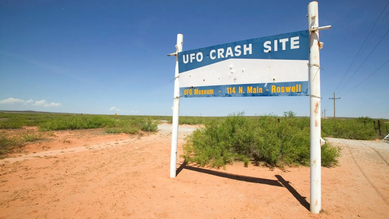 ein Schild in der Wüste mit der Aufschrift UFO-Absturzstelle, UFO-Museum 114 North Main Street, Roswell