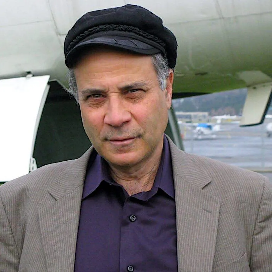 Ein Mann mit einer Mütze vor einem Flugzeug