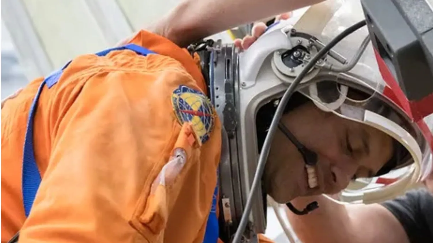 ein Astronaut, der sich mit Raumanzug und Helm vorbeugt