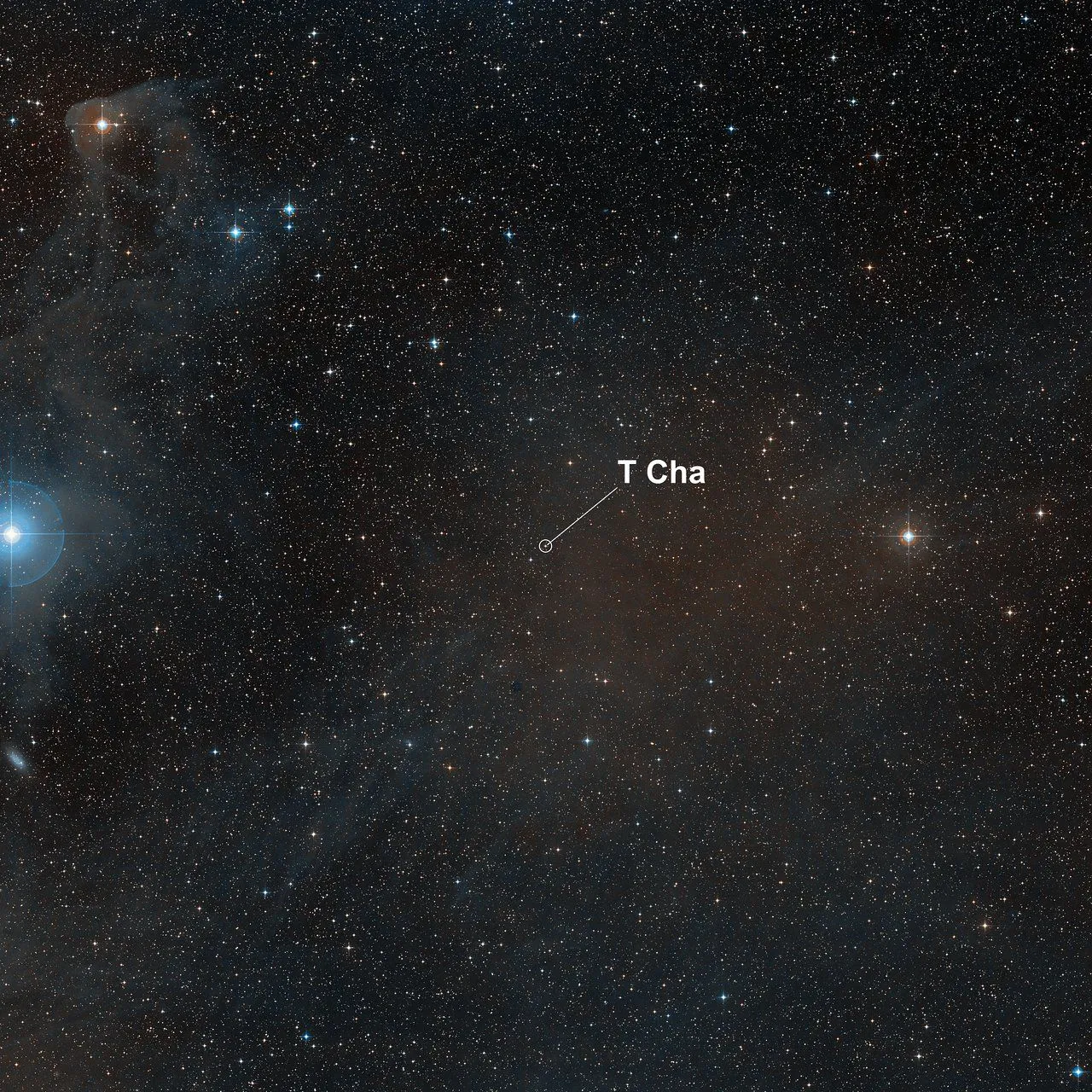 Ein Blick auf einen sternenübersäten Himmelsfleck mit einem Bereich, in dem ein Pfeil den Standort von T Cha anzeigt.
