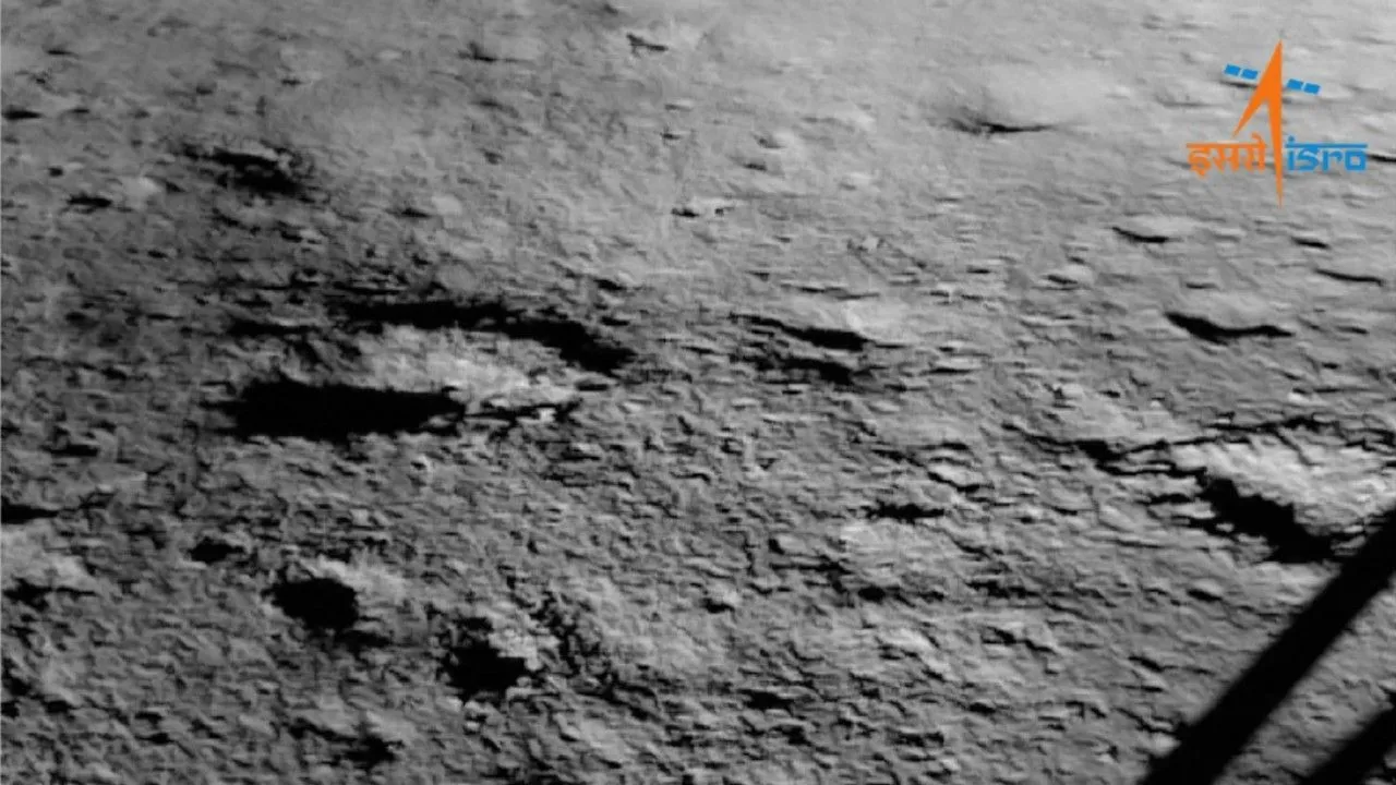 die graue Oberfläche des Mondes ist neben dem Bein einer Mondlandefähre zu sehen