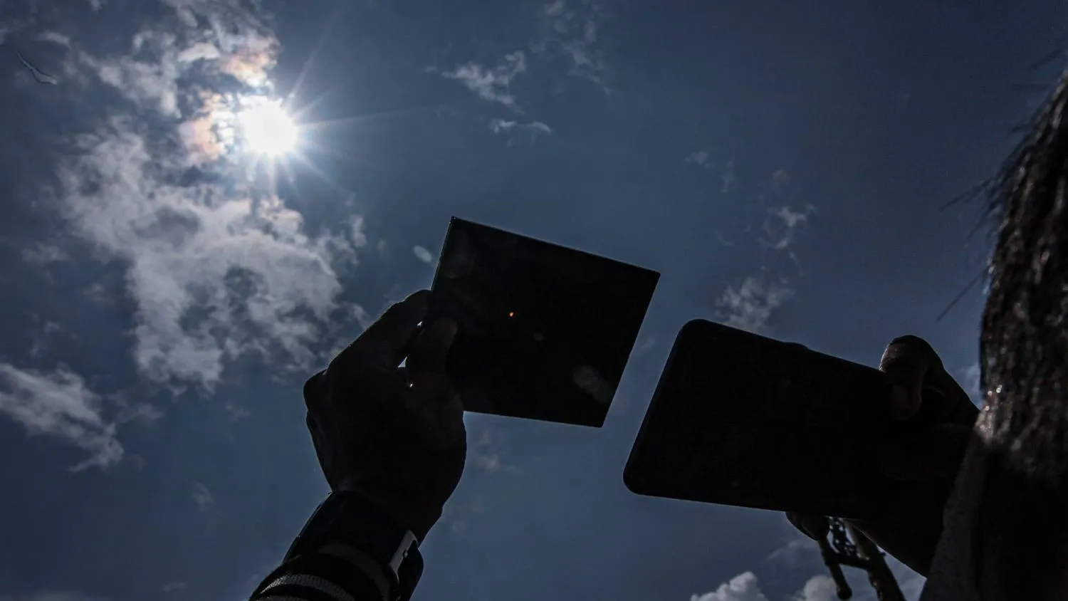 Ein Mann benutzt einen Schutzspiegel, um die Sonnenfinsternis in Palembang, Indonesien am 20. April 2023 zu beobachten