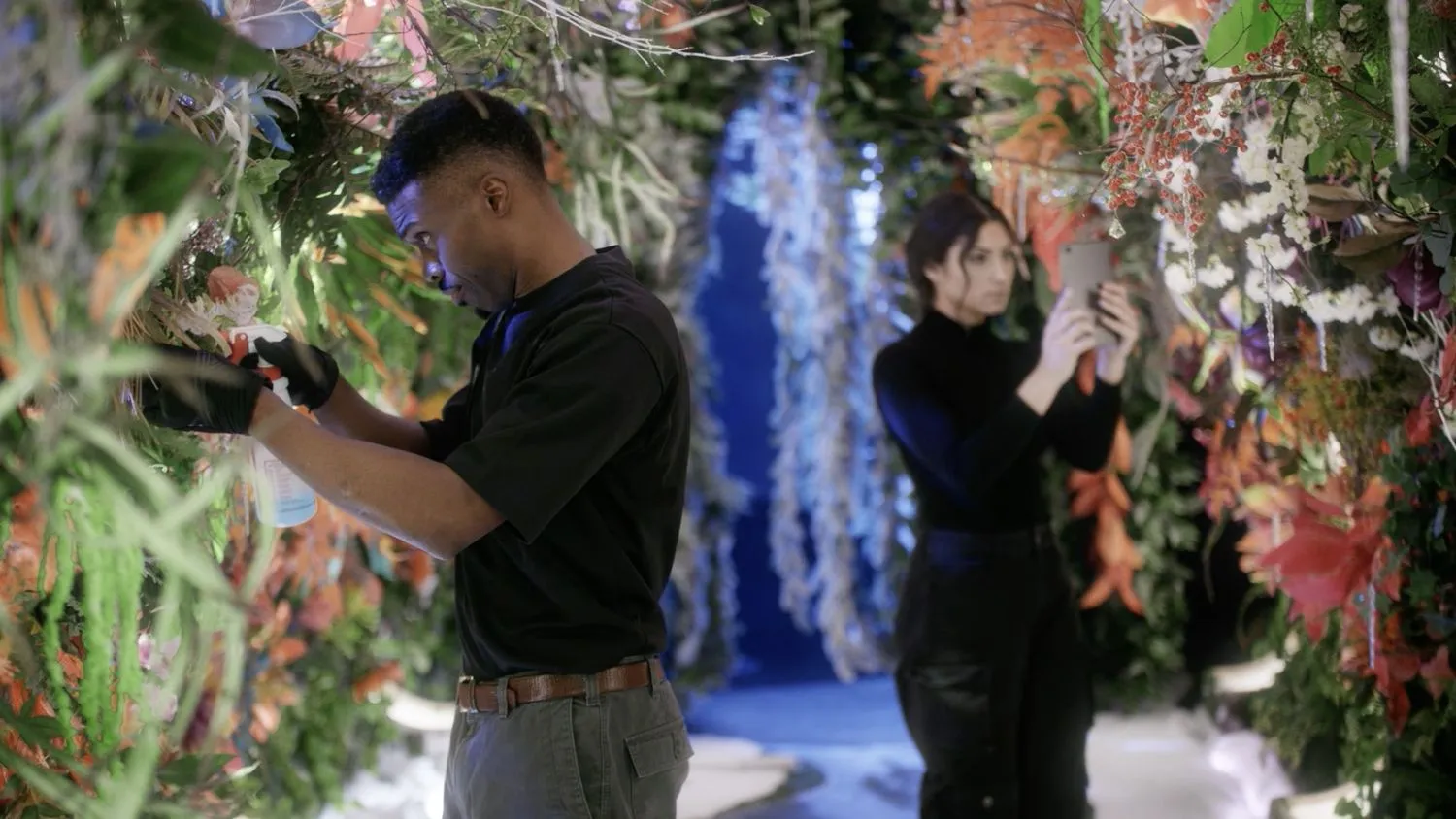 Zwei Menschen, die sich in einer futuristischen Umgebung um Pflanzen kümmern