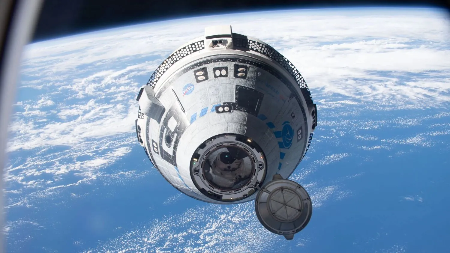 ein grau-blaues kegelförmiges Raumschiff im Weltraum über der Erde